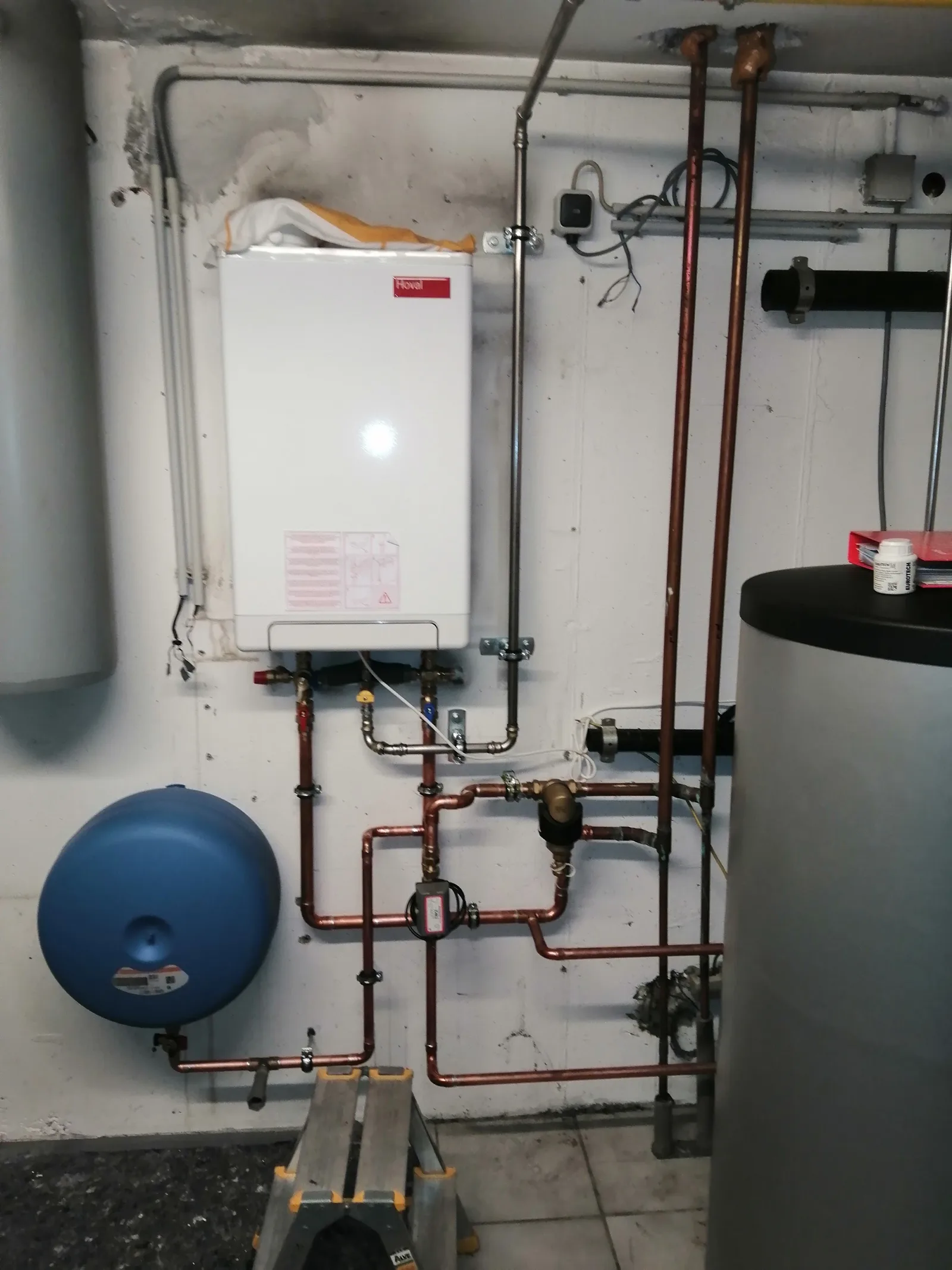 Gas-Wandtherme von Hoval im Keller, daneben Ausdehnungsgefäß und Speicher