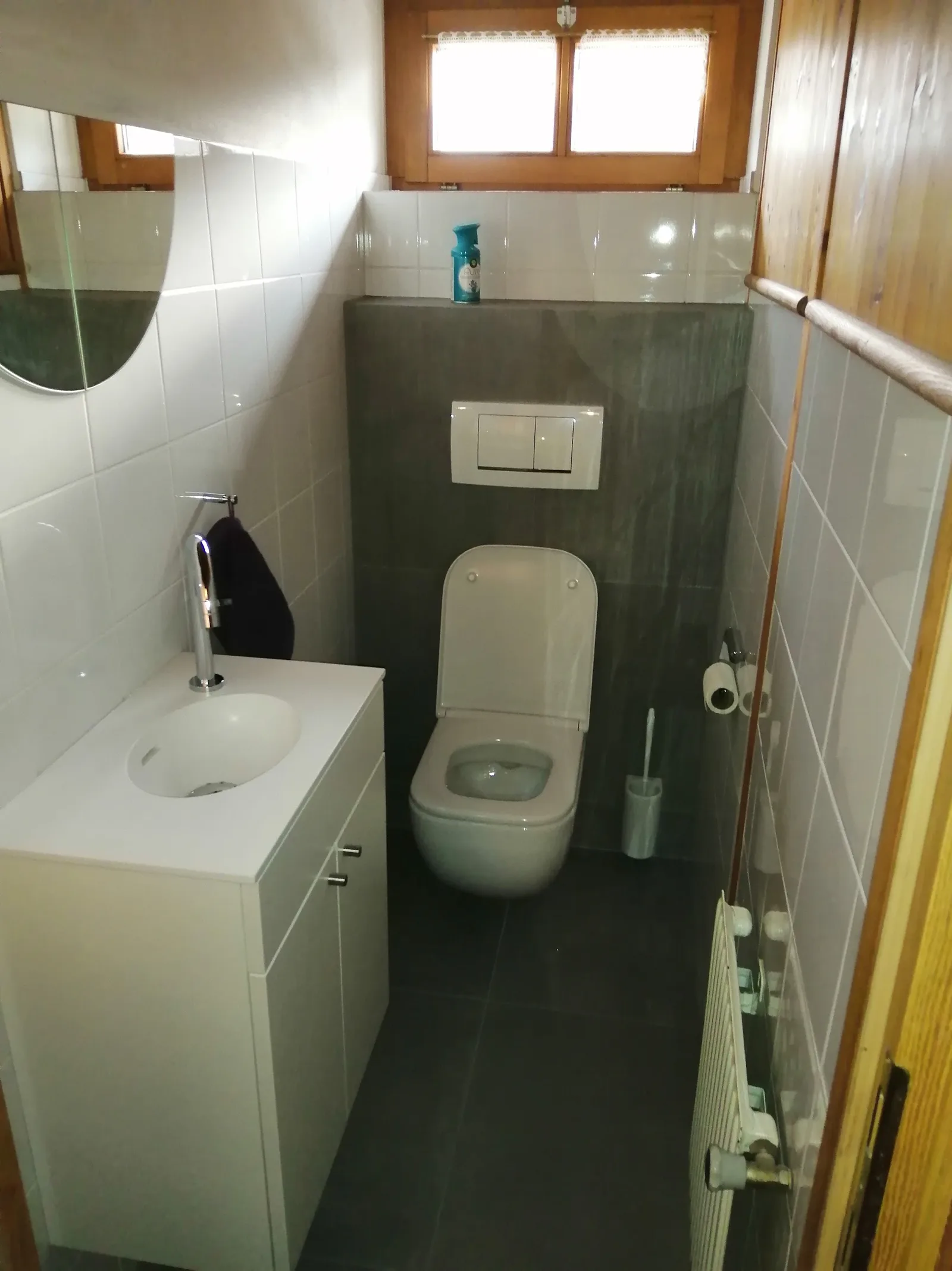 Gäste-WC mit Wand-WC, Waschtisch und Spiegel in einem Altbau